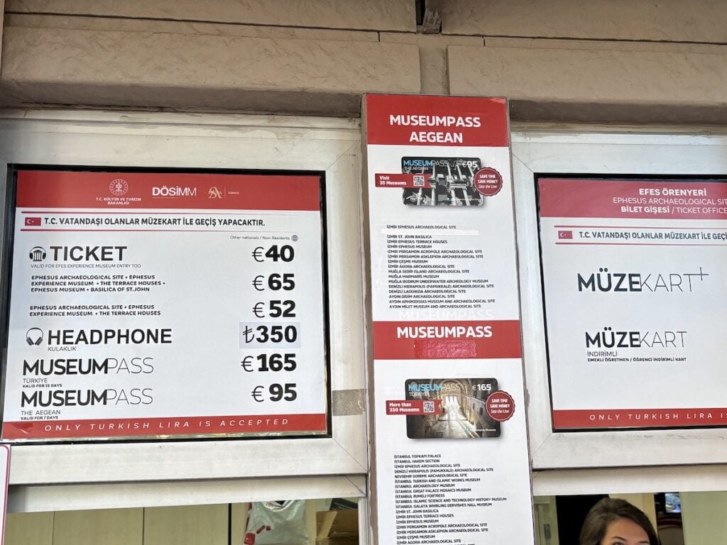 Ticketpreise Und Optionen für den Museumsbesuch, Darunter Einzeltickets, Kopfhörer Und Ephesus Museumspässe, Werden Auf Einer Tafel Angezeigt. Die Preise Sind In Euro Angegeben, Türkische Lira Werden Akzeptiert.