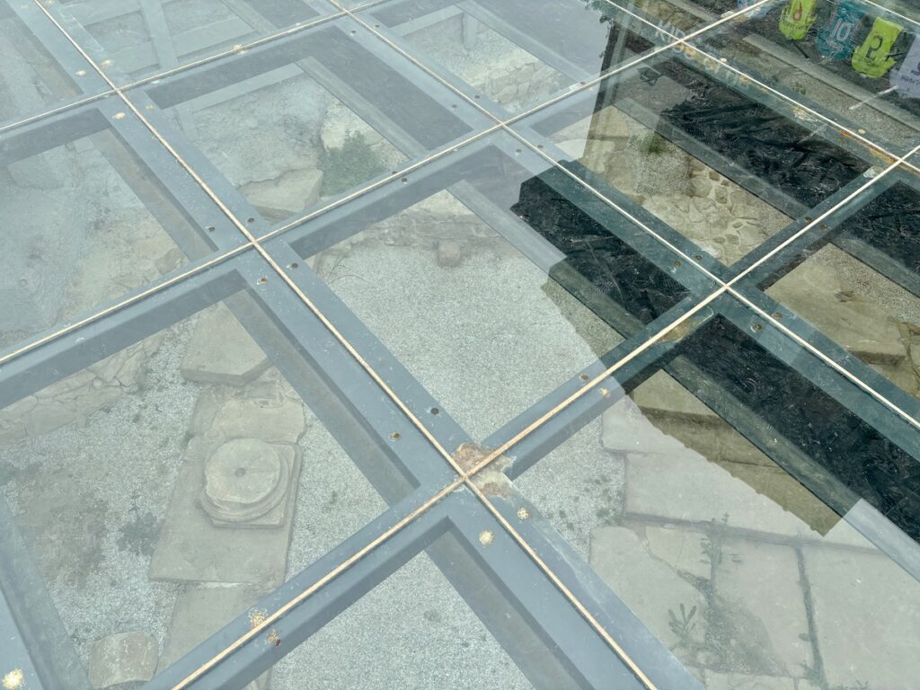 Eine gläserne Bodenplatte gibt den Blick auf die darunter liegenden antiken Ruinen frei, die von einem Metallrahmen umgeben sind und so für einen Hauch des Charmes der Altstadt Side sorgen.