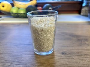 Ein Glas gefüllt mit Reiskörnern auf einem Holztisch