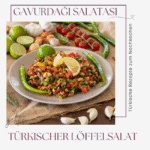 Ein Farbenfroher Teller Gavurdağı Salatası, Auch Bekannt Als Türkischer Löffelsalat, Ist Mit Zitronenscheiben Garniert Und Von Frischen Tomaten, Knoblauch, Paprika Und Limetten Auf Einer Rustikalen Holzoberfläche Umgeben.