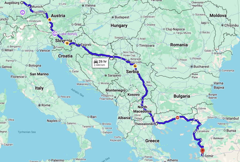 Karte mit einer Fahrtroute von Augsburg, Deutschland, nach Izmir, Türkei, für ein E Auto, die durch Österreich, Slowenien, Kroatien, Serbien, Nordmazedonien und Griechenland führt und 2.444 km in 26 Stunden zurücklegt.